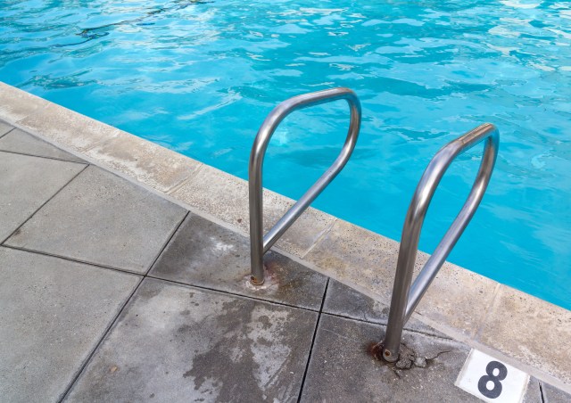 Swimming pool ladder handrail at deep end